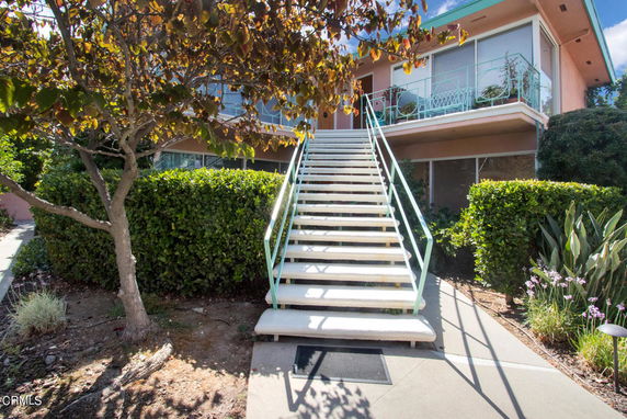 Front view of a building with an external staircase leading to the entrance.