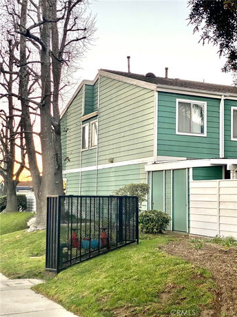 Side view of a two-story green house with white trim.