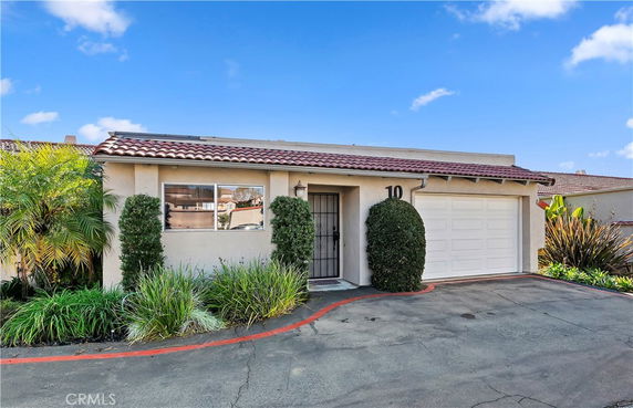 Front view of a single-story house with a tiled roof and attached garage.