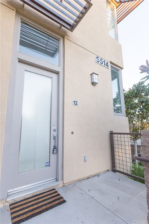 Front view of a modern house entrance with frosted glass door and exterior light.