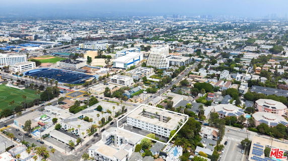 Panoramic view of a cityscape with various buildings and sports fields.