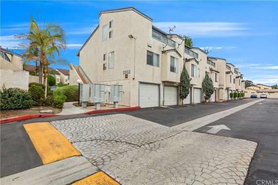 Front view of a row of multi-story townhouses with garages.