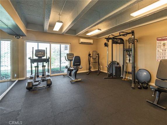 Indoor gym area with exercise equipment and large windows.