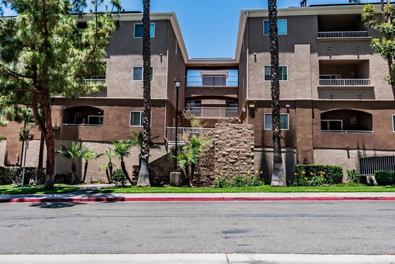 Front view of a multi-story apartment building with balconies.