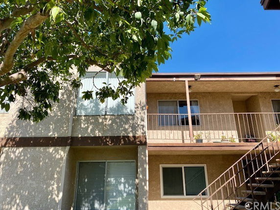 Front view of a two-story apartment building with balconies and stairs.