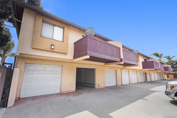 Front view of a two-story building with multiple garages and balconies.