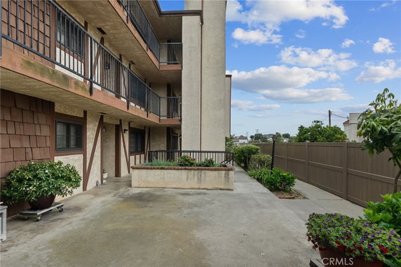 View of an apartment building exterior with balconies and garden space.