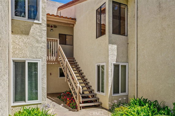 Exterior view of a two-story building with stairs leading to the second level.