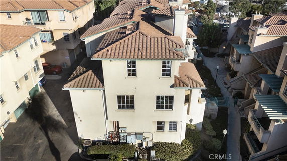 Aerial view of a multi-story residential building with a tiled roof.