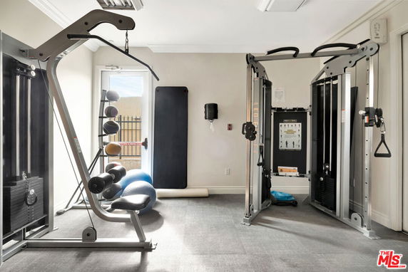 Indoor gym area with exercise equipment and mats.