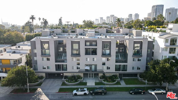 Front view of a multi-story apartment building with balconies and a modern design.
