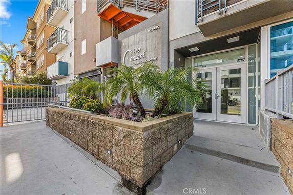 Front view of a condominium entrance with modern design and landscaped area.