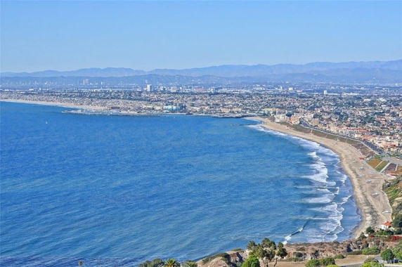 Wide-angle view of a coastal city with a long beach and ocean.