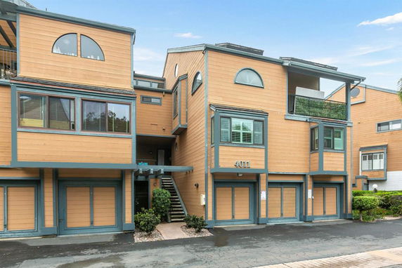 Front view of a multi-story residential building with balconies and arched windows.