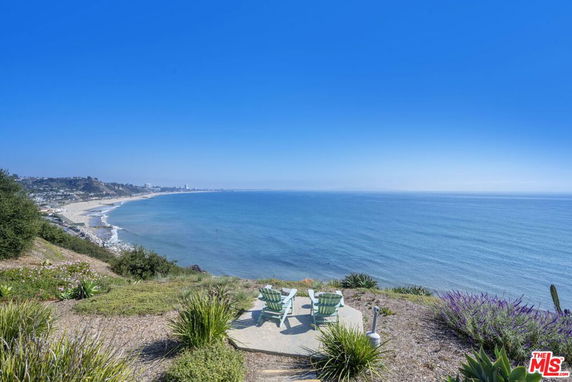 Panoramic view of a coastal area with a beach and oceanfront seen from a high vantage point.