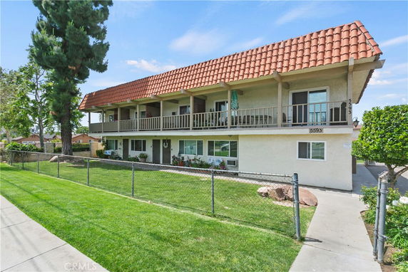 Front view of a two-story residential building with a tiled roof and multiple balconies.