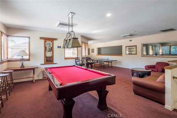 Recreation room with a pool table and seating area.