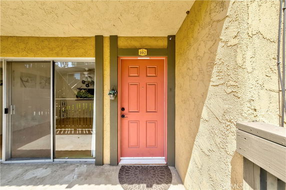 Front view of a building entrance with a red door and sliding glass door