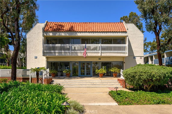 Front view of a two-story building with a tile roof and a balcony.