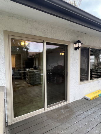 Front view of a house with a sliding glass door and attached outdoor light fixture.