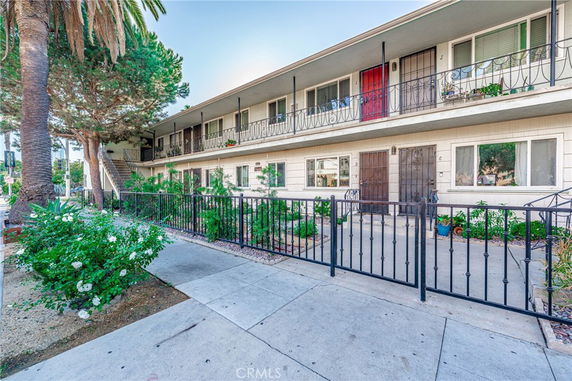 Front view of a two-story apartment building with outdoor walkways and staircases.