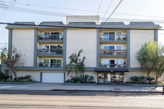 Front view of a multi-story apartment building with balconies.