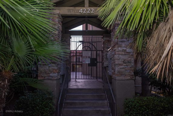 Entrance view of a building with stone columns and a gated entrance.
