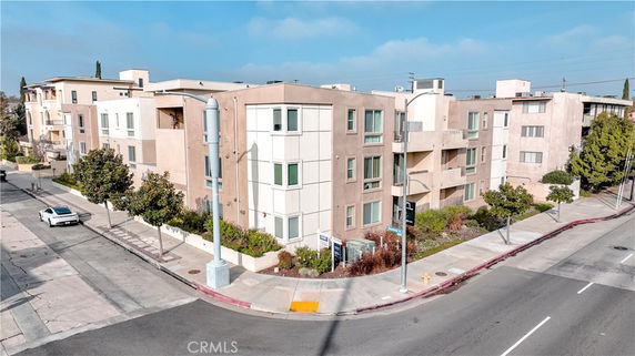 Front view of a multi-story apartment building on a street corner.