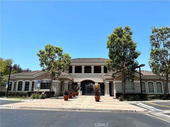 Front view of a two-story building with a symmetrical design and arched entryway.