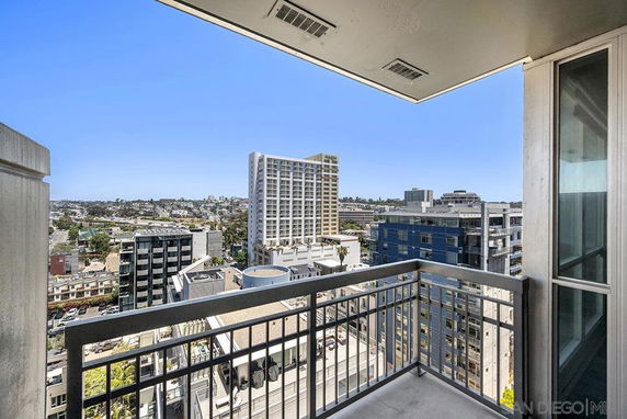 View from a balcony overlooking city buildings and skyline.