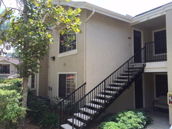 Exterior view of a two-story building with an outdoor staircase leading to the upper level.