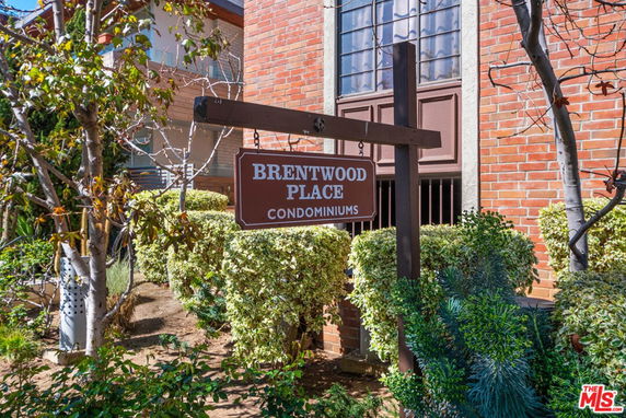 Front view of a condominium building with a sign reading 'Brentwood Place Condominiums'.
