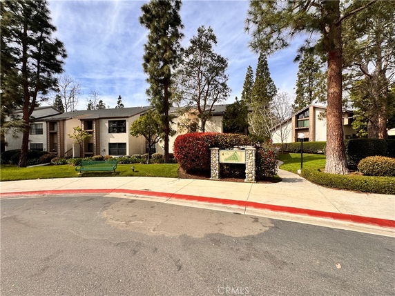 Front view of a residential building with trees and landscaping.
