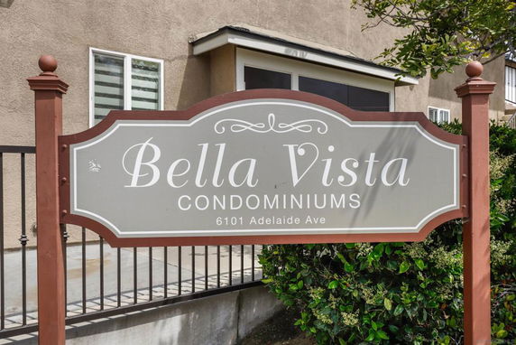 Front view of Bella Vista Condominiums with a building sign and part of the structure visible.