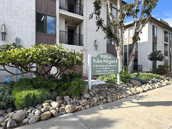 Front view of a multi-story condominium with balconies.