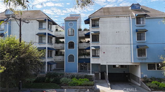 Front view of a multi-story residential building with blue and white exterior.