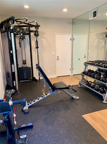 Indoor gym area with workout equipment and a wall mirror.