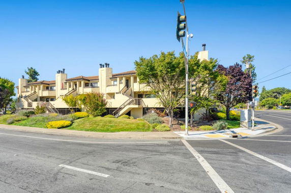 Front view of a multi-story apartment building at a street corner.