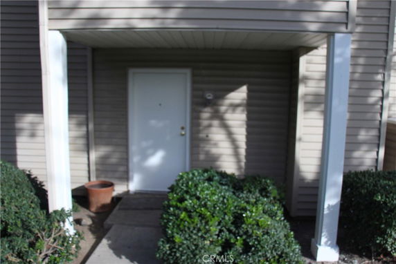 Front view of a covered entrance with a white door.