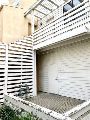 Front view of a two-story house with white wooden paneling and a covered entrance.