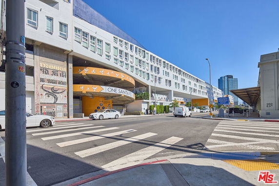 Front view of a modern multi-story building with a distinctive curved design and artwork on the facade.