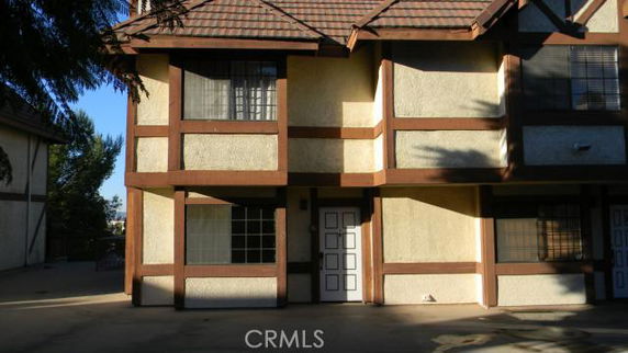 Front view of a two-story house with brown trim and a tiled roof.