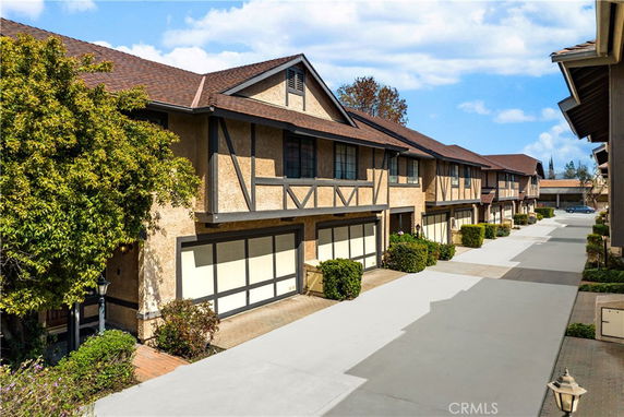 Front view of a row of two-story townhouses with garages.
