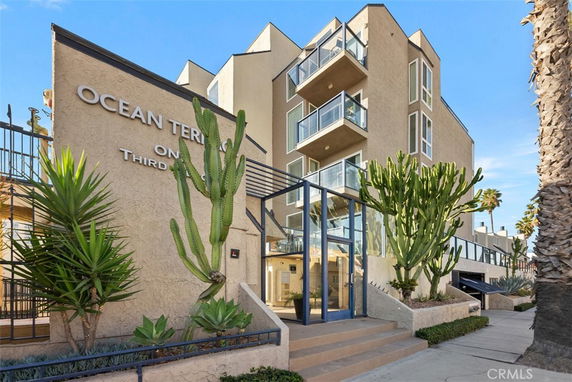 Front view of a multi-story building with balconies and large windows.