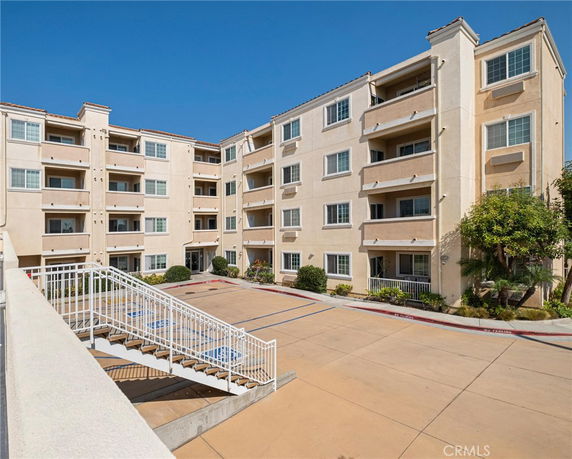 Front view of a multi-story apartment building with balconies.