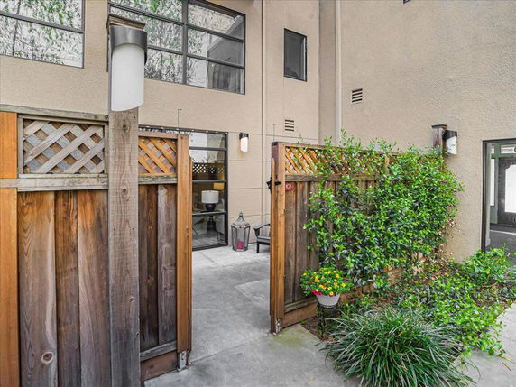 Front view of a building with a wooden fence and plants.