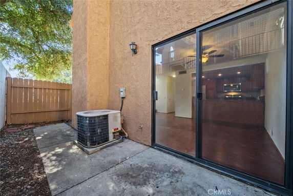 Exterior corner view of a house with large sliding glass doors leading inside.