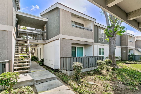 Front view of a two-story apartment building with external staircases.