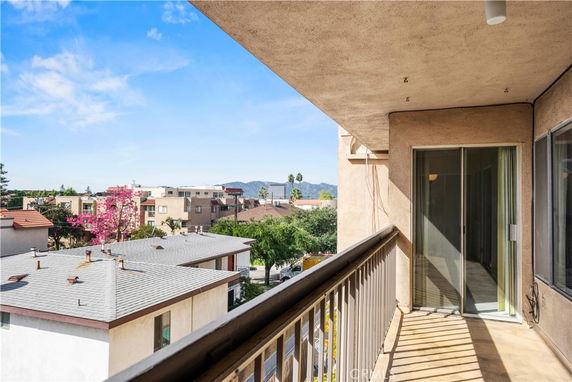 View from a balcony overlooking buildings and distant mountains.