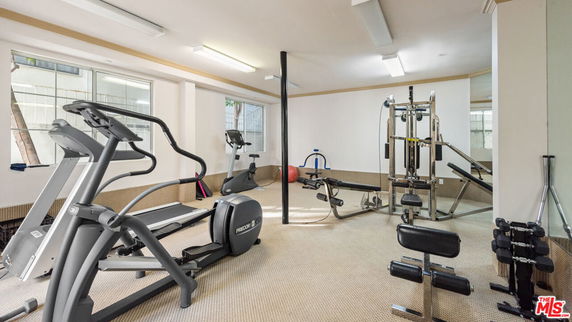 Indoor gym with exercise equipment including treadmills and weight machines.